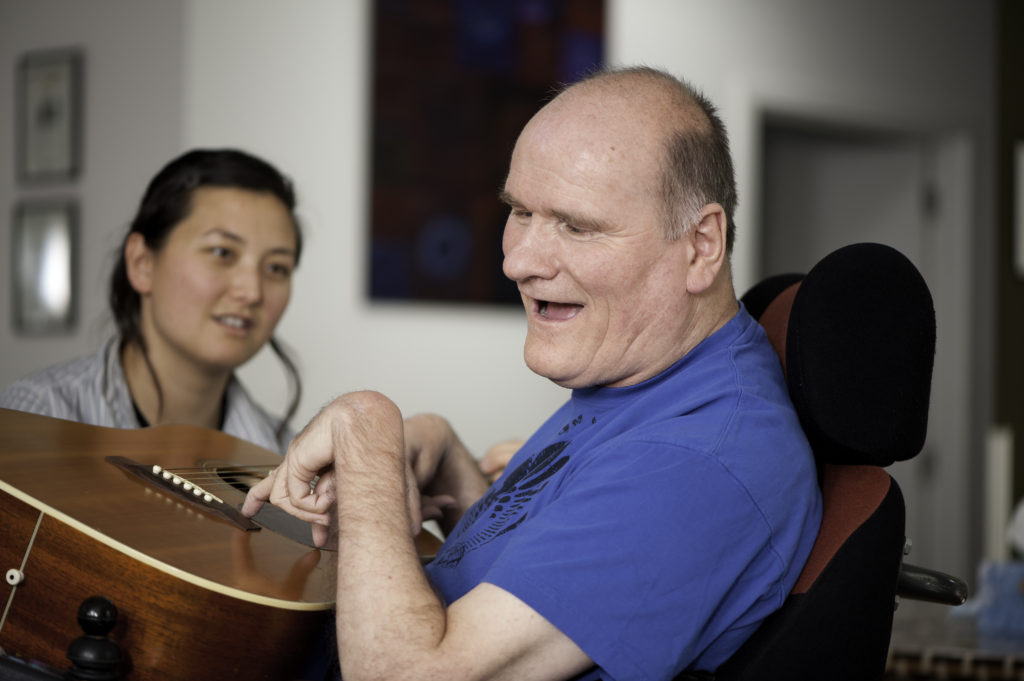 This man was having a sing-a-long with a support worker.  She held the chords while the man strummed.